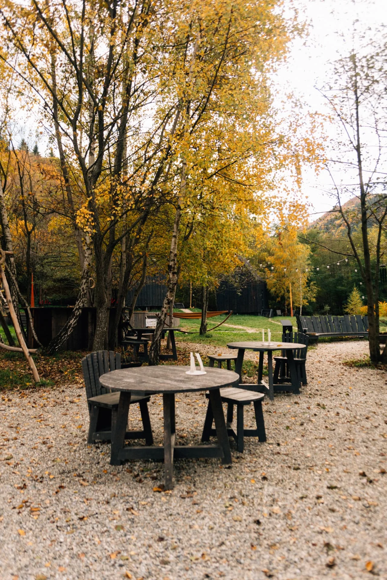 Mese de lemn în curtea Portal Village toamna