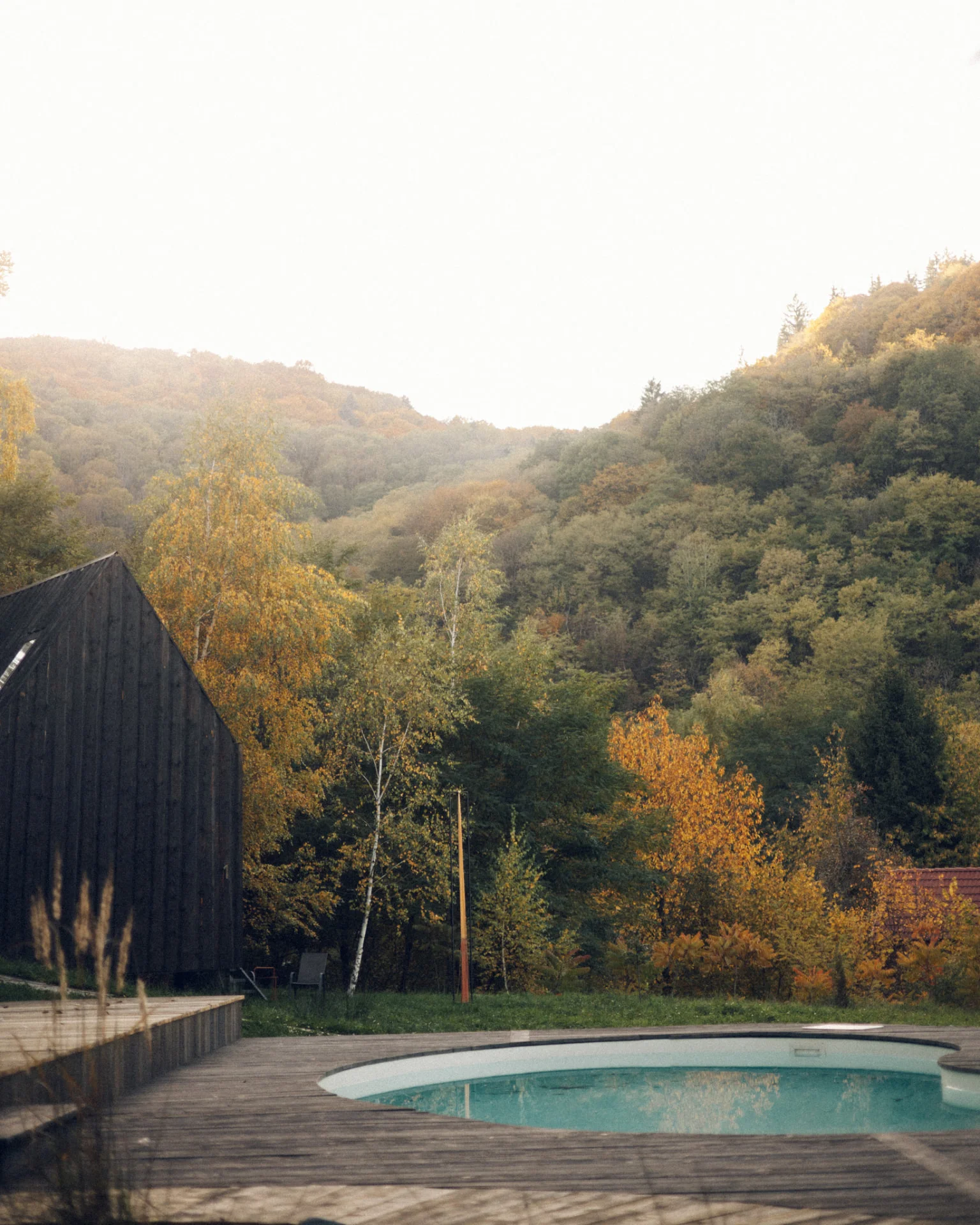 Piscina încălzită de la Portal Village, cu dealurile în culorile toamnei